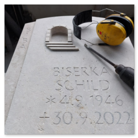 Ein kleines, handgearbeitetes Symbol (z.B. ein Tor mit Treppe) im Stein.