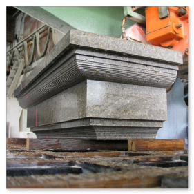 CNC-gesteuerte Bearbeitung von großen Steinblöcken aus Muschelkalk in der Werkstatt.