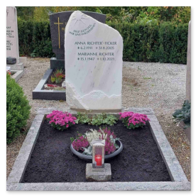 Grabstein mit einer kunstvoll eingearbeiteten, strahlenden Sonne.