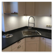 Flächenbündig eingelassener Bio-Abfalleimer in einer Granitplatte.