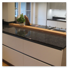 Freistehende Küchenhalbinsel aus Naturstein mit Sitzbereich.