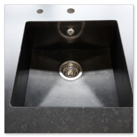 In die Arbeitsplatte integriertes Unterbaubecken aus Naturstein ohne sichtbare Fugen.