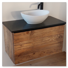 Aufgesetztes Keramikbecken auf einer Natursteinplatte mit Altholz-Unterschrank.