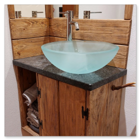 Stilvolles Badezimmer-Ensemble mit gläsernem Waschbecken und rustikalem Altholz-Unterbau.